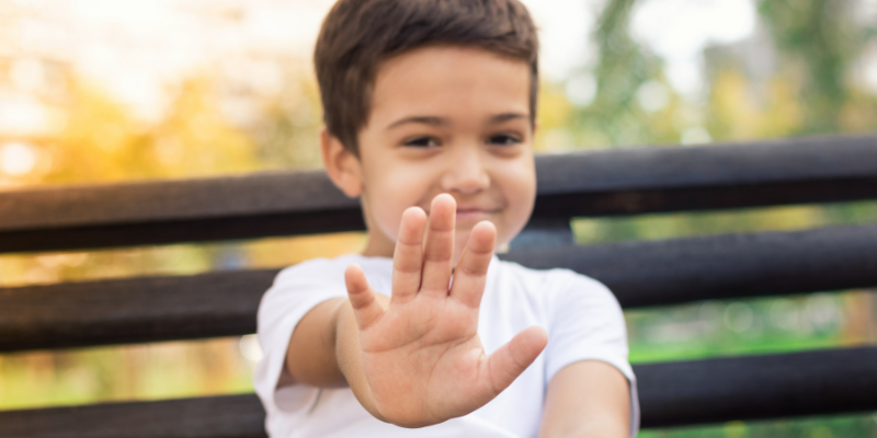 Child holding hand up to say "NO!"