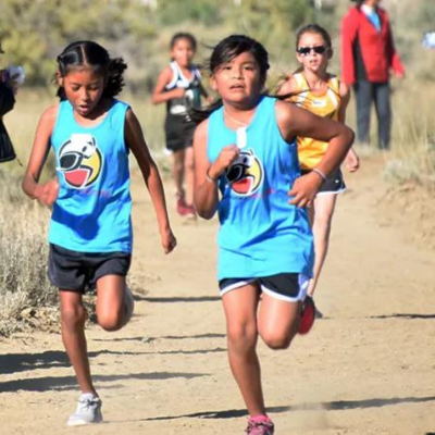 Two Acoma Pueblo youth running wearing Running Medicine t-shirts.